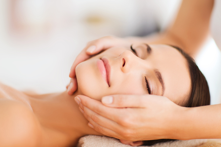 beautiful woman in spa salon having facial
